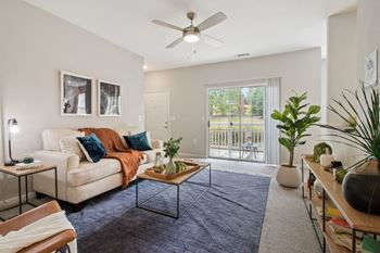 a living room with a couch and a ceiling fan at The Enclave at Crossroads, Raleigh